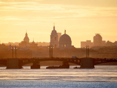 Köprünün üzerinde altın bahar günbatımı. Rusya 'daki Neva Nehri üzerindeki Saint Petersburg şehri. Tarihi Rus mimarisi ile şehir silueti renkli fotoğraf. Şehrin kartpostal görüntüsü.