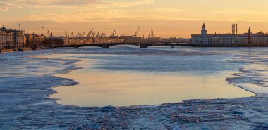 Bahar akşamı St. Petersburg. Neva Nehri 'nde buz erir. Palace Köprüsü 'nün gün batımı manzarası, şehir hayatı, akşam şehrin kartpostal manzarası. Panoramik görünüm. 