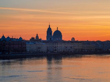 Şehirde altın bahar günbatımı. Rusya 'daki Neva Nehri üzerindeki Saint Petersburg şehri. Tarihi Rus mimarisi ile şehir silueti renkli fotoğraf. Şehrin kartpostal görüntüsü.