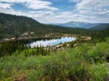 Orman dağı gölü. Vadideki dağ gölü. Dağ vadisinde kayaları olan kristal mavi gölün yaz manzarası. Batı Sayan 'da yürüyüş. Ergaki Doğa Parkı 'nın muhteşem manzarası.. 