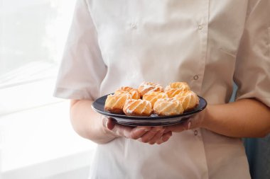Kadın şefin taze ve lezzetli hindistan cevizli kurabiyeleri tutarken çekilmiş görüntüsü..