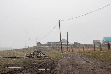 Yumuşak odaklanma, görüş mesafesi zayıf. Sonbahar boyunca kar. Dağın altında küçük bir köy. Rusya 'nın Belyashi köyü Altai Krai' de karlı ve sisli bir günün altın sonbahar manzarası..