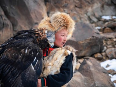 Ulgiy, Moğolistan - 30 Eylül 2023: Kuzey Moğolistan. Altın kartal avlayan bir çocuğun portresi. Kartal avcıları Moğolistan 'da altın kartallarla eğitip avlanan bireylerdir..