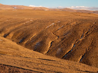 Dağların alışılmadık dokusu, kayanın damarlarında kar var, platonun yüzeyi güneş tarafından ısıtılıyor. Gün batımında inanılmaz kırmızı dağ yaylası hafifçe karla kaplanır.. 