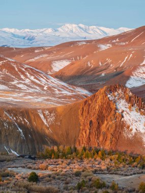 Dağ nehri vadide harika bir dağ manzarası sonbahar renklerinde ormanlar mavi gökyüzünün altında kızıl dağ siluetleri. Sonbaharda güzel bir dağ vadisi. Dikey görünüm.