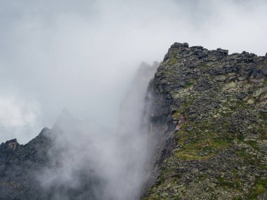 Dev kayalık dağların arasında dramatik bir sis. Büyük kayalıklara hayali atmosfer manzarası. Alçak bulutlar ve güzel kayalar. Minimalist manzara gizemli bir yer..