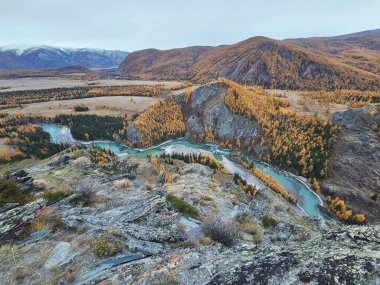 Argut nehrinin yukarısındaki granit kayalık. Sonbahar vadisindeki çarpıcı turkuaz nehri. Dağlardaki güzel sonbahar manzarası, nehir ve renkli orman.