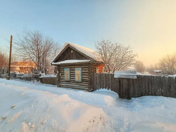 Winter in the Russian countryside. Snowdrifts in front of the entrance to the farmhouse. Rural life and way of life preserved to the present day. Winter street in the village of Cherdyn, Perm region.