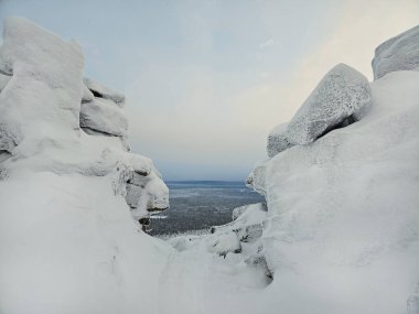 Tehlikeli kış vadisi, iki kar kayası arasında bir uçurum. Dev kayalık dağlar arasında dramatik bir manzara. Alçak bulutlar ve güzel kayalar. 