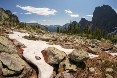 Karlı taşlı geçitler, büyük renkli dağ sıraları ve uzak yeşil vadiler. Kar beyazı buzullar en güzel kayalık tepede, mavi gökyüzündeki bulutların altında. Batı Saiyanlar.