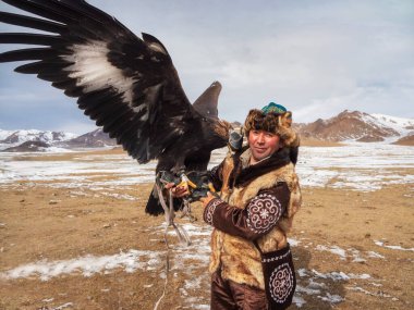 Ulgii, Moğolistan - 30 Eylül 2023: bir yarışmada altın kartal avlayan deneyimli bir erkek avcının portresi. Kartal avcıları Moğolistan 'da altın kartallarla eğitip avlanan insanlardır..