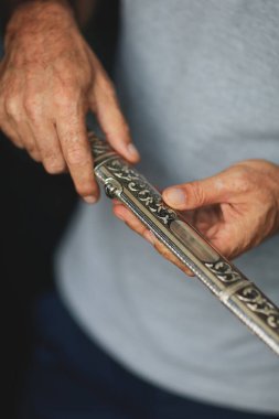 Seçici odaklanma. Hançer ustasının elleri iş başında, yakın plan. Kubachin kuyumcusu. Gümüş bıçak kınalı, el yapımı, yaratılış süreci. Bireysel mühendislik üretim kavramı.