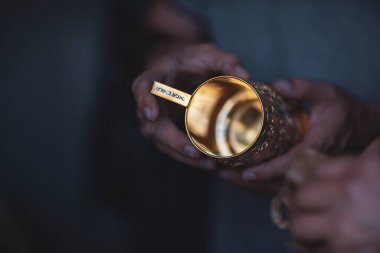 Seçici odaklanma. İş yerindeki bir kuyumcunun elleri, yakın plan. Altın bardak tutacağı, el yapımı, yaratılış süreci. Kubachi kuyumcu ustası iş başında. Bireysel mühendislik üretim kavramı.