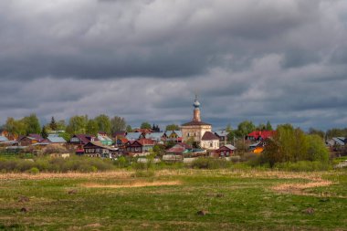 Kilisenin ve Suzdal 'daki kıyı ahşap evlerin muhteşem manzarası. Suzdal en eski Rus kasabalarından biridir ve önemli bir turistik merkezdir..