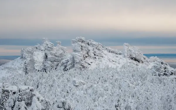 stock image Rock cliff, Kolchinsky stone is covered with fluffy frost. Winter weather,  top of mountain. Low temperatures froze trees and rocks into ice. Coniferous forest as in fairy tale 