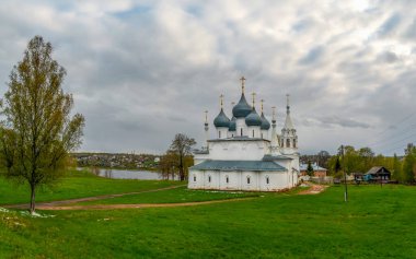 Ancient Holy Cross Cathedral with tree garden at spring in Tutaev, Russia. Panoramic view. clipart