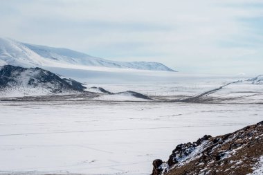 Moğolistan 'da kar yağıyor. Yol karla kaplı tepelerin çok uzağında. Kış vahşi doğası.