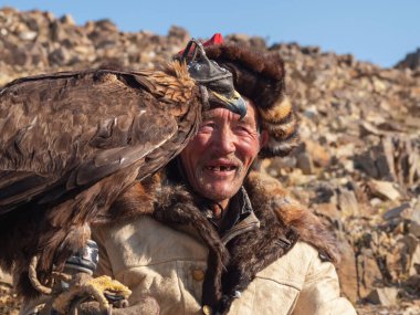 Ulgiy, Moğolistan - 30 Eylül 2023: Altın kartal avlayan çok yaşlı bir erkek avcının portresi. Yaşlı göçebe ve avcı kuş. Moğolistan.