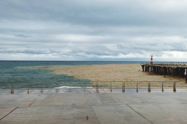 Demiryolu, deniz kenarında bir bariyer. Şiddetli yağmurlar denizi kirletti. Denizde renkleri karıştırıyorum. Karadeniz.