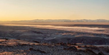 Dağ yaylasıyla gündoğumu manzarası. Hafif yoğun sis yere yayılıyor. Uzaktan görüntüle.