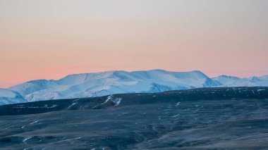Göz kamaştırıcı kar dağları, tepeler güzellikleri ve ihtişamlarıyla büyülüyor. Yürüyüş izleri nefes kesici panoramalara yol açar. Dağlar alacakaranlıkta.