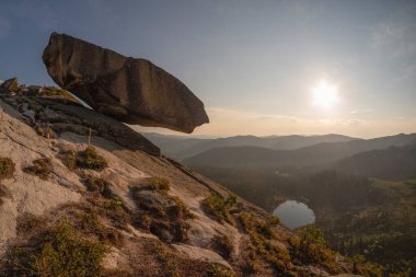 Doğanın alışılmadık bir fenomeni. Büyük granit kaya uçurumun üzerinde asılı duruyor.. 