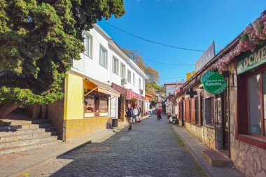 Gurzuf, Kırım - 17 Ekim 2024: Gurzuf, şehrin eski sokağı. Gurzuf sokaklarında yürüyen turistler. Gerçek bir şehir hayatı. Güzel bir sonbahar günü.