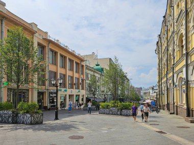 Moskova, Rusya - 14 Temmuz 2024: İnsanlar yaz günü Moskova 'da Kuznetsky Most Caddesi boyunca yürüyorlar. Modern şehir hayatı. Tarihi evler ve malikaneler.