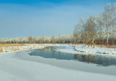 Ormandaki bir nehrin inanılmaz güneşli kış manzarası. Kar resmi. Kar ve nehir.