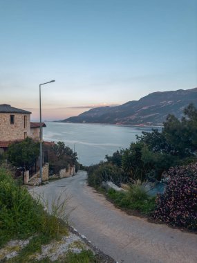 Gün batımından sonra Kas 'ta güzel bir taş binanın dikey görüntüsü. Akşamları Kaşhindi. Denize açılan bir sokak..