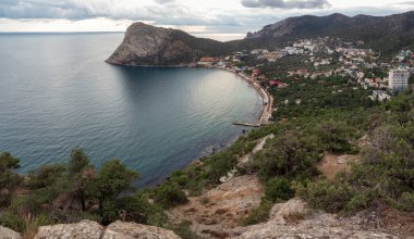 Kırım 'daki Novy Svet tatil köyünün panoramik manzarası. Dağların, denizin, pelerinin, kayaların manzarası.
