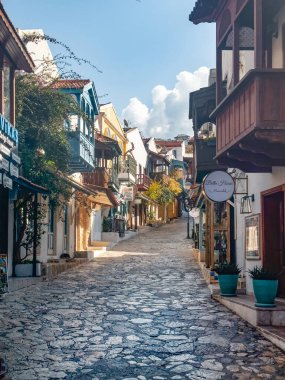 Kasım. Türkiye, 16 Şubat 2025, akşam saatlerinde butik dükkanları olan Kas 'ın eski şehir manzarası. Kas Town Türkiye 'de popüler bir turizm merkezidir. Kış zamanı, turist yok. Dikey görünüm. 