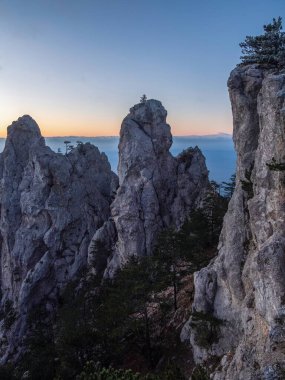 Şafaktan önce büyük taş dağ. Resmedilmeye değer kayalıklı doğal bir manzara. Dağ sırası Ai-Petri, Kırım Cumhuriyeti. Dikey görünüm