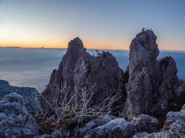 Şafaktan önce büyük taş dağ. Ön planda donmuş çimenler. Resmedilmeye değer kayalıklı doğal bir manzara. Dağ sırası Ai-Petri, Kırım Cumhuriyeti. 