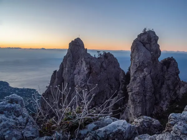 Şafaktan önce büyük taş dağ. Ön planda donmuş çimenler. Resmedilmeye değer kayalıklı doğal bir manzara. Dağ sırası Ai-Petri, Kırım Cumhuriyeti. 
