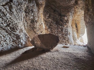 Mağaranın içindeki büyük granit kaya. Yeraltı mağarasından çıkan ışık. Kurtuluş.