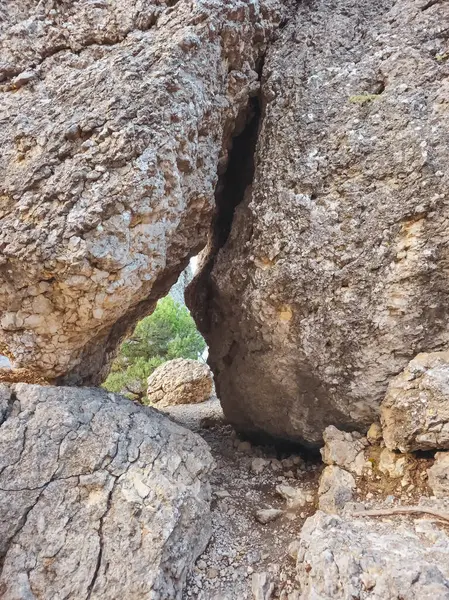 Granit kayalıklardaki dar rögar boşluğunda yürüyüş yapmak, mağara girişi. Mağarada dar bir delik. Dikey görünüm.