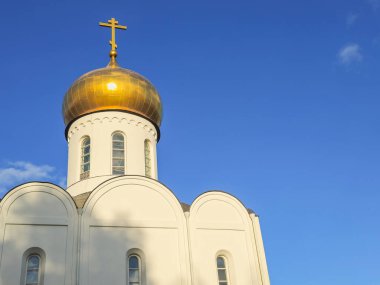 Beyaz Ortodoks Kilisesi 'nin alttaki manzarasında güneşli, yaldızlı bir kubbe açık sonbahar mavi gökyüzüne karşı. Pimen Ugreshsky Tapınağı Dzerzhinsky, Moskova.