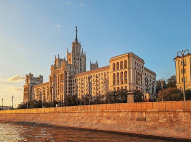 Moskova, Rusya - 11 Temmuz 2024: Moskva Nehri üzerinde gökdelen, altın akşam gün batımı. Kotelnicheskaya seti üzerinde ünlü bir gökdelen.