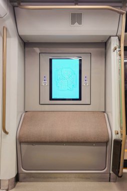 Moskova metro trenlerinde bir metro haritası olan parlak bir monitör. Metro vagonundaki yolcular için yastıklı bir koltuk. USB yükleniyor. 