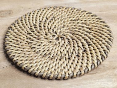 Kağıt bir sarmaşıktan yapılmış el yapımı, yuvarlak örülmüş bir altlık. Yuvarlak yer bezi.