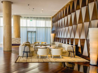 Abu Dabi, BAE - 31 Mayıs 2024: Abu Dabi otelinin modern lobisi. Yumuşak deri koltuklar, yuvarlak masalar, parlak renkli rahat sandalyeler..