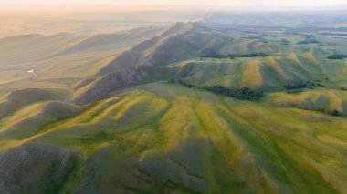Yumuşak odaklanma. Hava görüntüsü. Vahşi dağlarda yaz manzarası. Güzel doğa manzarası resmi. Tepeler mesafeye kadar uzanıyor. Tepeler ve vadiler. Orenburg, Rusya. 