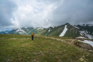 Vahşi yaşam fotoğrafçısı, yüksek dağlarda, bir yamaçta duran kamerasıyla çarpıcı bir manzara yakalıyor. Fotoğrafçının gözü aşağıdaki vadinin nefes kesici manzarasına kayar..