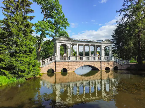 Puşkin, Rusya - 16 Ağustos 2025: Catherine parkındaki mermer köprü, Tsarskoye Selo, Saint Petersburg banliyösü. İnsanlar parkta yürüyor ve turistler manzaranın tadını çıkarıyorlar..
