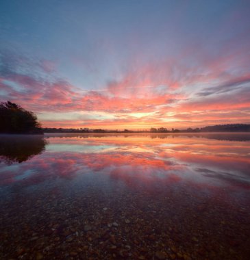 Güzel ve huzurlu günbatımı Lugo Galiçya yakınlarındaki bir lagünün sularına yansıdı.