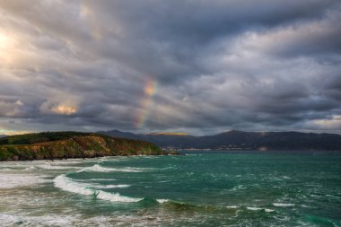Espasante ve Ortigueira Galicia 'daki Loiba kıyılarında günbatımında renk spektrumu ve anti-linik ışınları