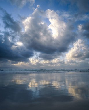 Pamuklu kümülonimbus bulutları Ribadeo Lugo Galiçya 'daki plajda ve denizde toplanıyor.