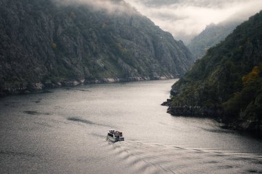 Bir tekne, Ribeira Sacra Lugo Galicia 'daki Sil Nehri' nin granit kayalıkları arasında turistik bir tura çıkıyor.