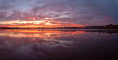 Bir gölün durgun suları Begonte Lugo Galiçya 'da güzel bir gündoğumunu yansıtır.